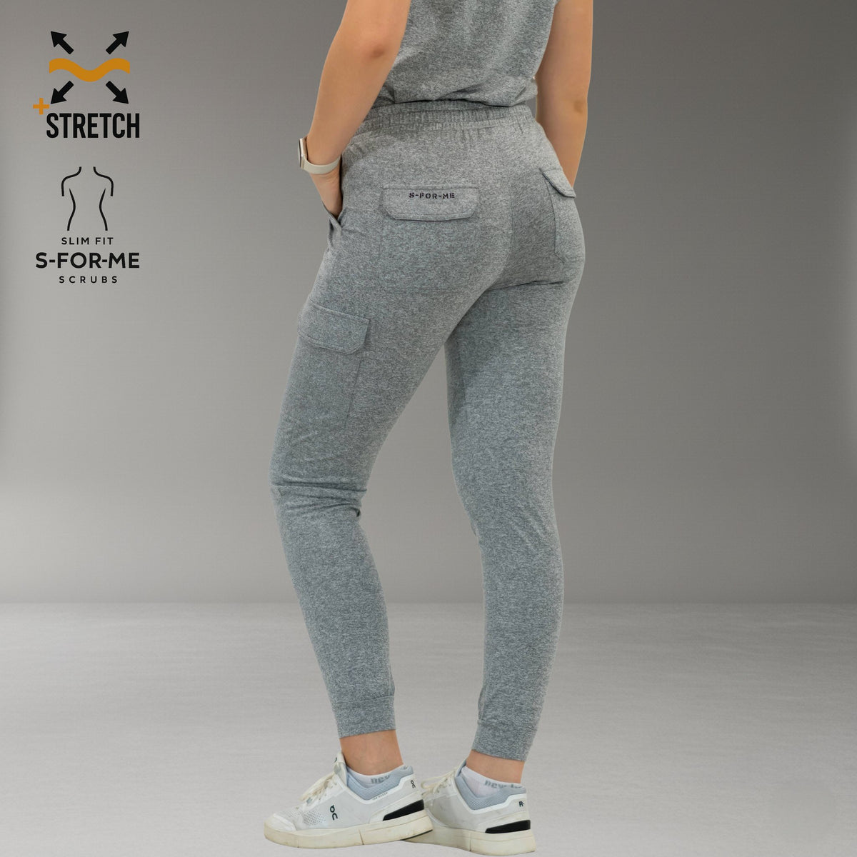 Jogger Style 905 gris jaspeado, vista posterior de tres cuartos mientras la modelo se gira.