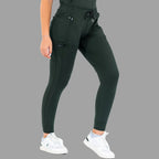 Three-quarter front view of women's scrub joggers 920 super stretch bottle green with legs apart.