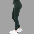 Profile view of women's scrub joggers 920 super stretch bottle green with hands resting.