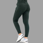Side back view of women's scrub joggers 920 super stretch bottle green with one foot forward.