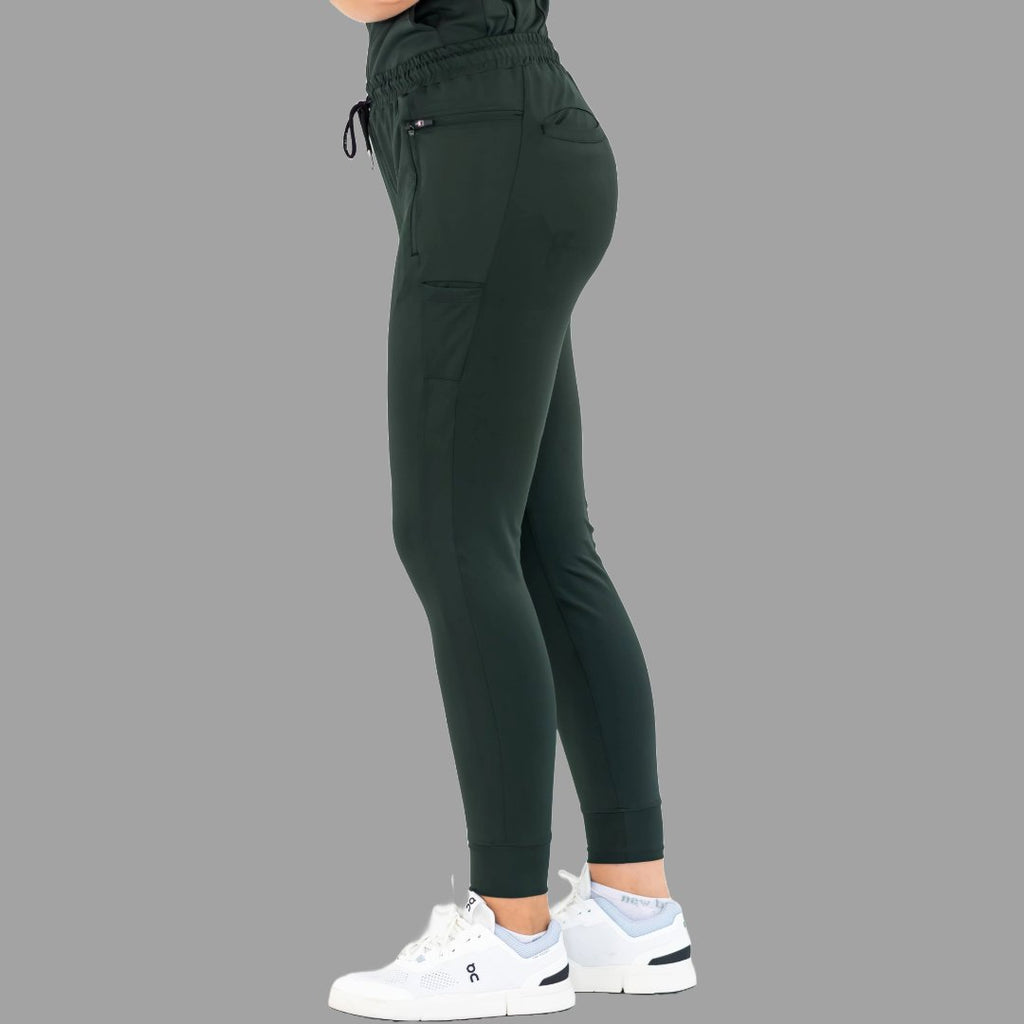 Side profile view of women's scrub joggers 920 super stretch bottle green on a grey background.