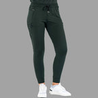 Three-quarter front view of women's scrub joggers 920 super stretch bottle green with feet apart.