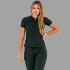 Woman walking forward in a bottle green 920 super stretch scrub top with one hand on hip.