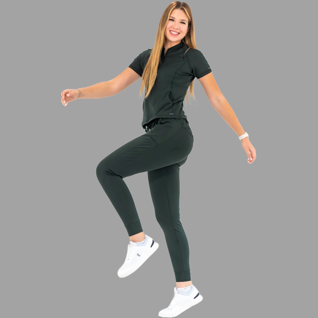 Full body action pose of a woman stretching in a bottle green 920 super stretch scrub outfit.