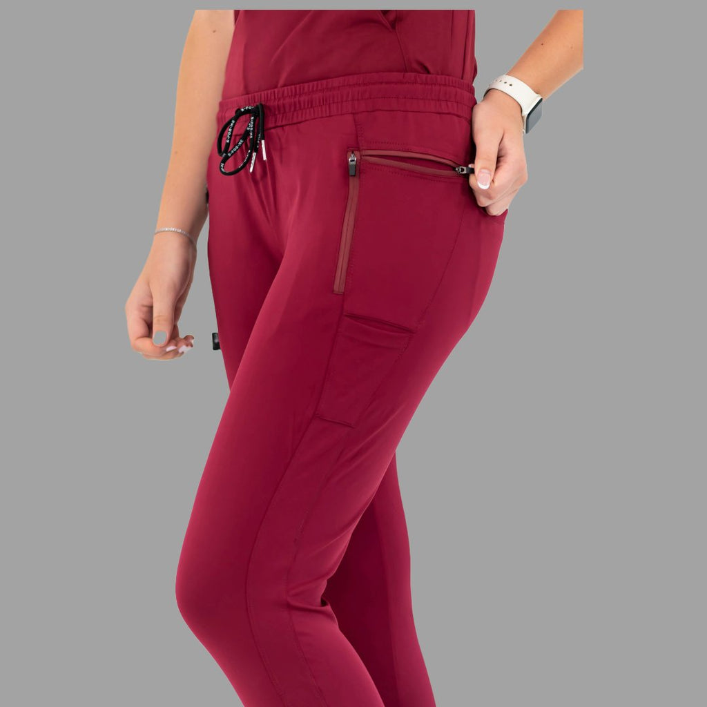 Close-up front view of burgundy women's joggers 920, showing hand in the side pocket.