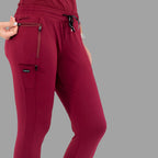 Close-up front-side view of burgundy women's joggers 920, showing hand near the pocket.