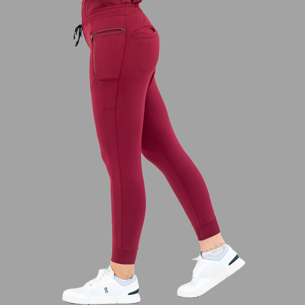 Side view of burgundy women's joggers 920, showing left leg stepping back.