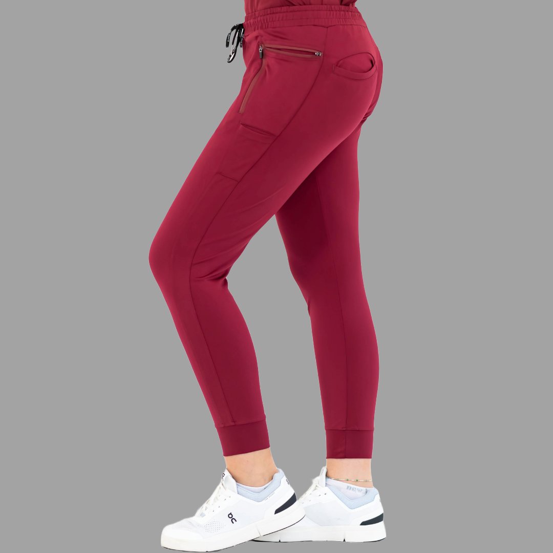 Side view of burgundy women's joggers 920, right leg slightly forward.