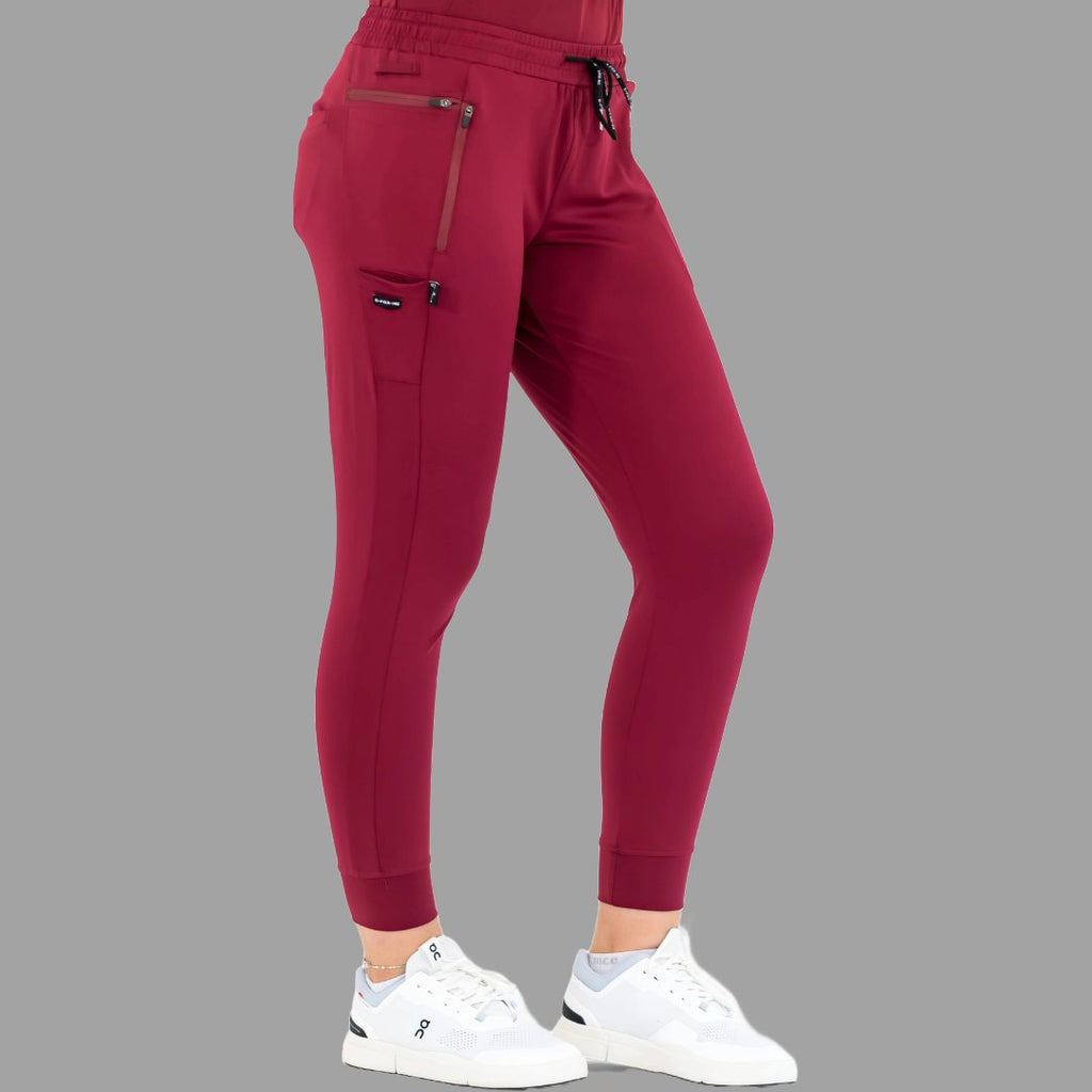 Side view of burgundy women's joggers 920, left leg slightly forward.