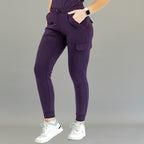 Jogger quirúrgico mujer 905 uva Super Stretch, vista frontal de tres cuartos con las manos en los bolsillos.