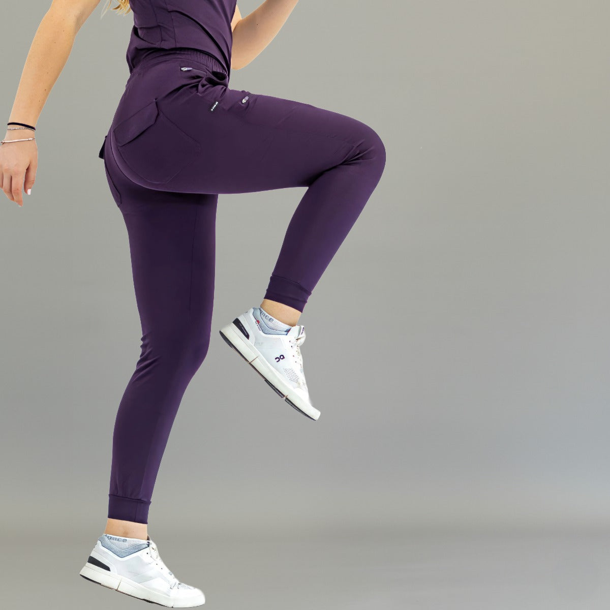 Jogger quirúrgico mujer 905 uva Super Stretch, vista lateral con una pierna levantada.
