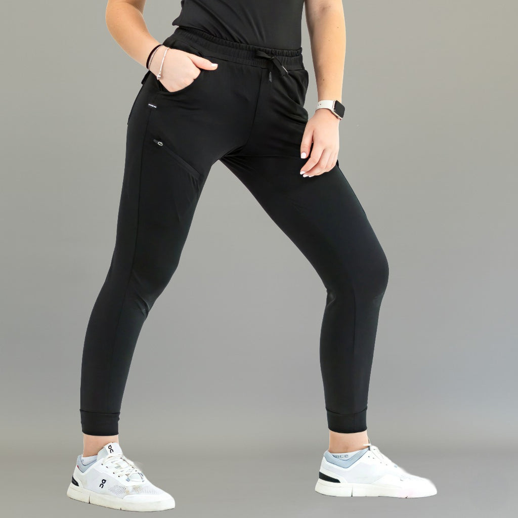 Pantalón quirúrgico jogger negro 905 de mujer, vista frontal en modelo, con puños en el tobillo.