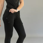 Detalle frontal del jogger negro 905: cintura fruncida, cordón y bolsillo delantero con cremallera.