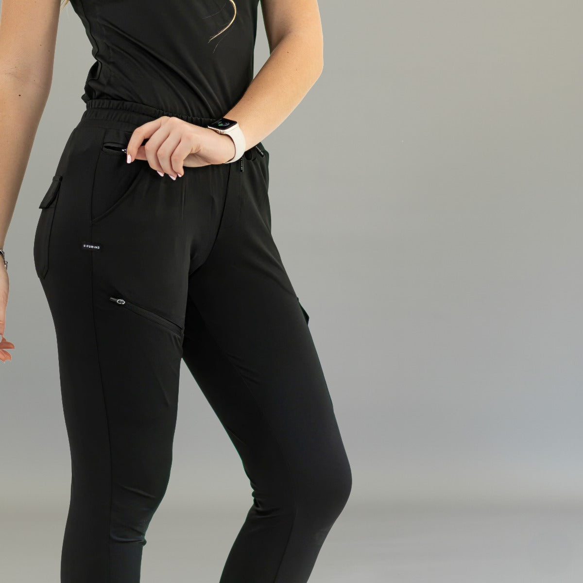 Detalle frontal del jogger negro 905: cintura fruncida, cordón y bolsillo delantero con cremallera.