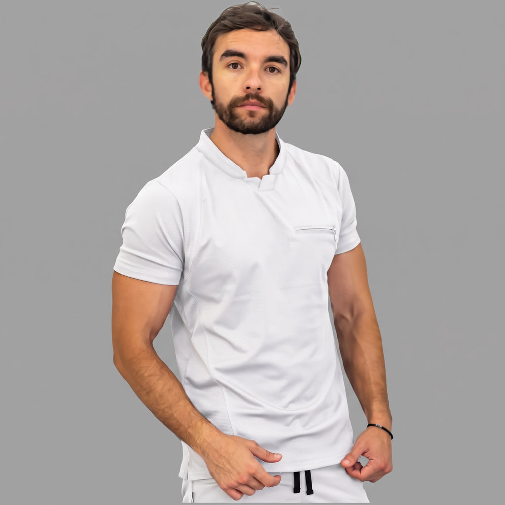 scrubs-blanco-trescuartos.jpg: "Modelo en pose de tres cuartos con la filipina quirúrgica Est. 910 blanca, mostrando su ajuste y caída."